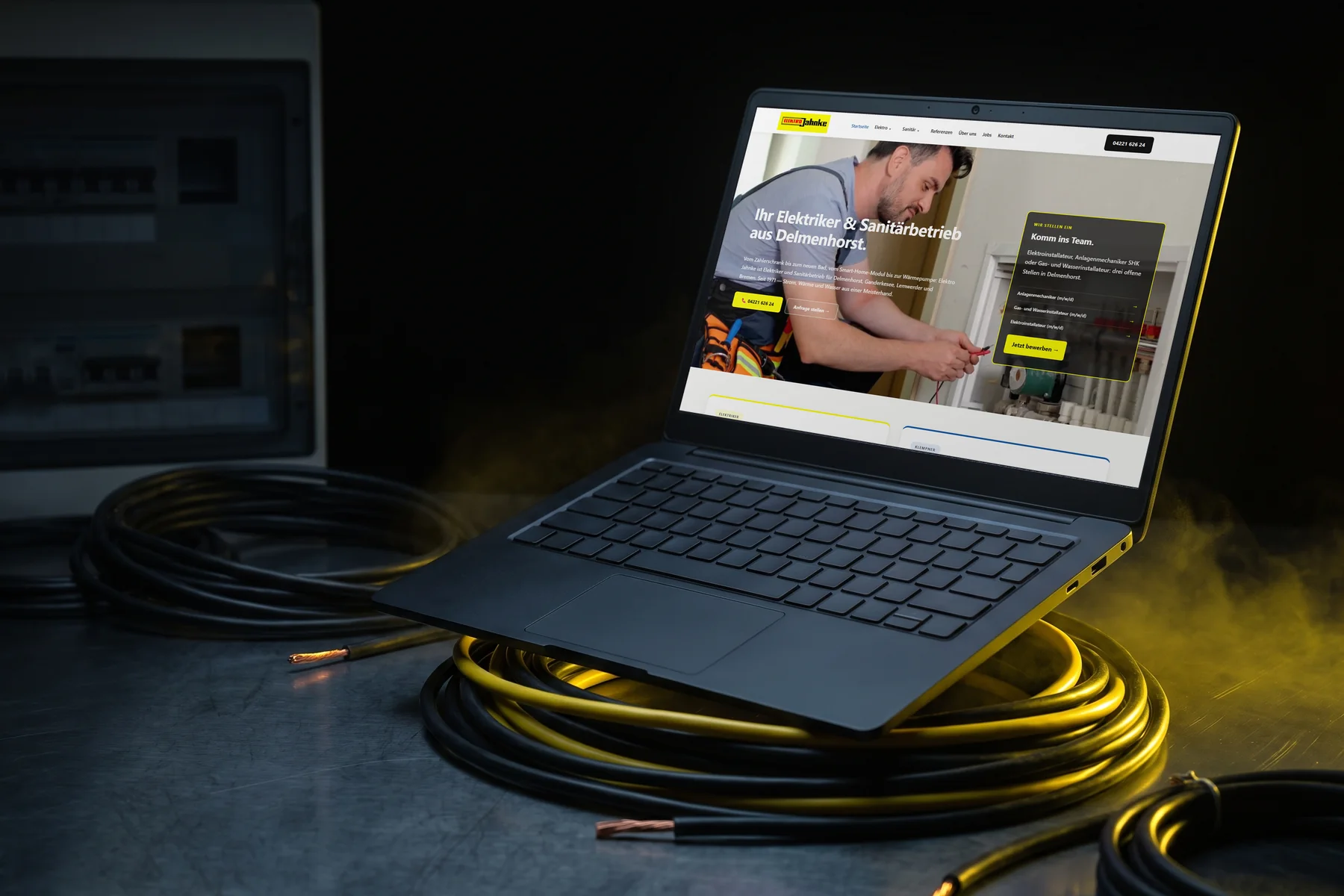 Laptop auf einer Kabelrolle zeigt die Website eines Elektro- und Sanitärbetriebs: Handwerker-Website als Referenz.