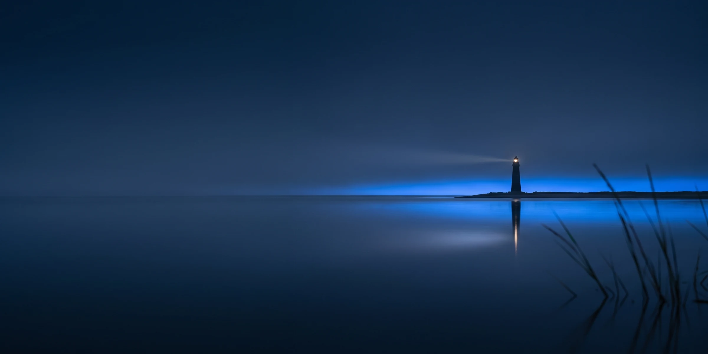 Norddeutsche Küstenlinie zur blauen Stunde mit der Silhouette eines Leuchtturms: die Herkunft von Media-Nord.com.
