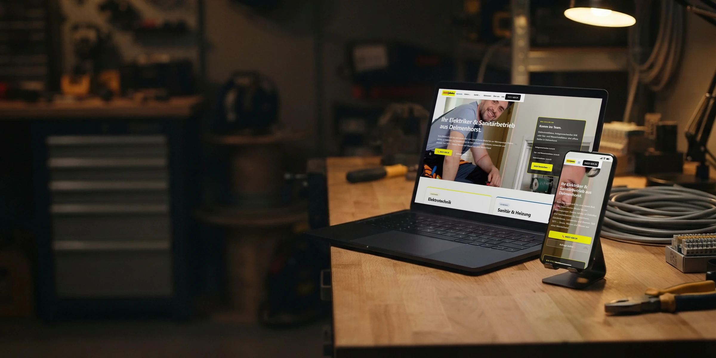 Webseite von Elektro Jahnke auf Laptop und Handy auf der Werkbank: Webdesign für Handwerker