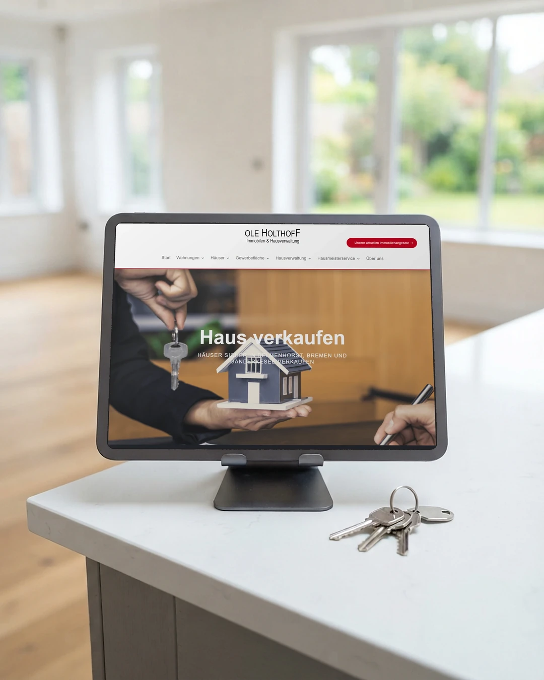 Homepage für Immobilienmakler: Haus verkaufen am Tablet Seite Haus verkaufen von Ole Holthoff Immobilien auf dem Tablet im leeren Haus: Homepage für Immobilienmakler